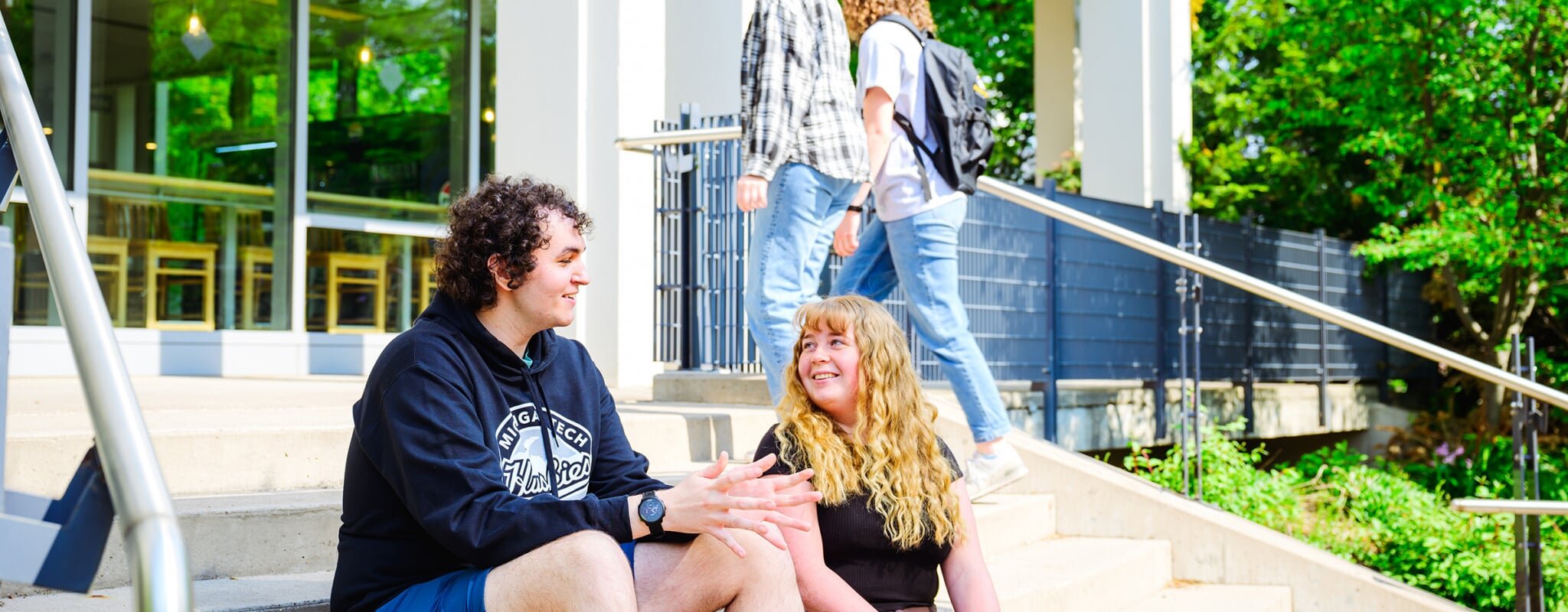 Students sitting outside the library on campus