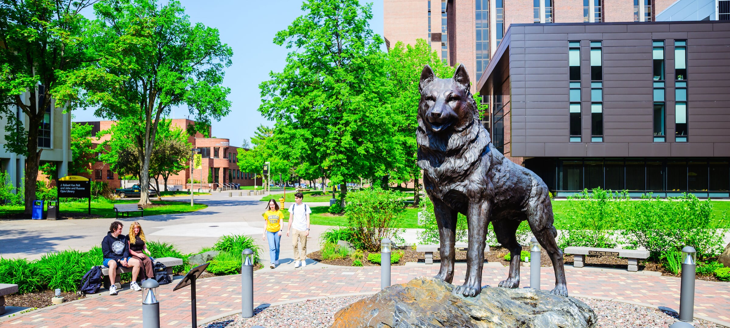 Students walking near the Husky statue on Michigan Tech's campus