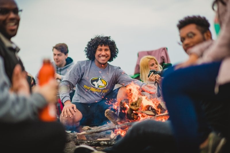 Michigan Tech students around a campfire on the beach.