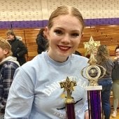 Student holding trophies after a Dance Team competition.