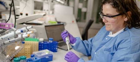 A research scientist for Michigan Tech’s Genomic Sequencing Lab works with equipment in the facility.