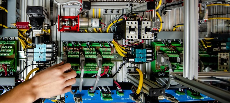 Plugging in a cord in an electronics panel.