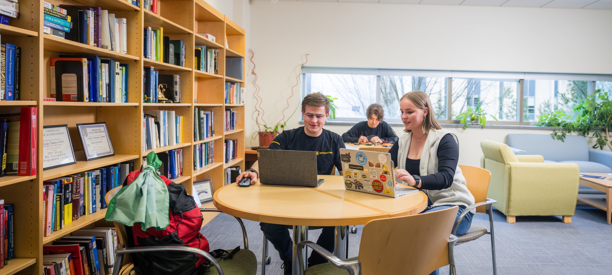 Michigan Tech students working on a laptop at a table.