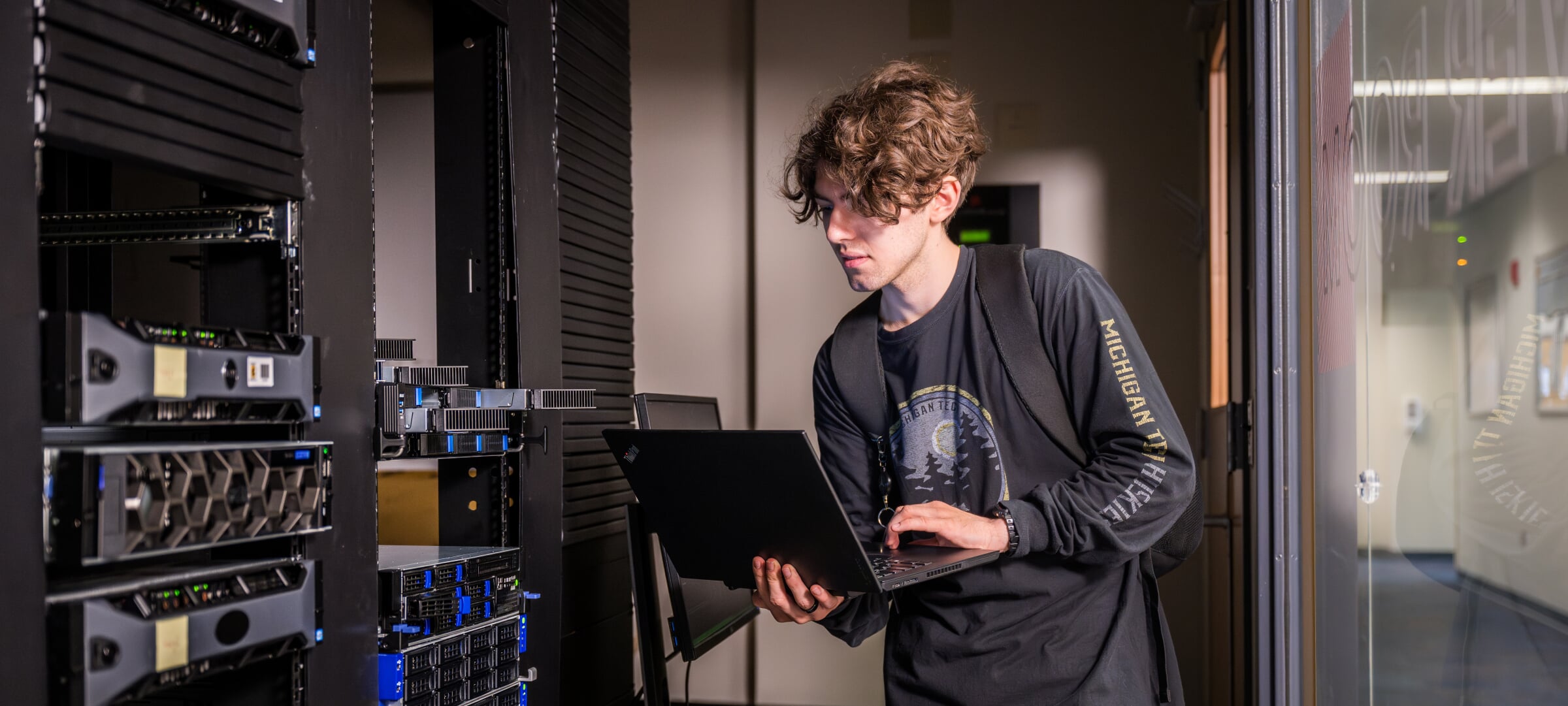 Information Technology student using a laptop to work with servers.