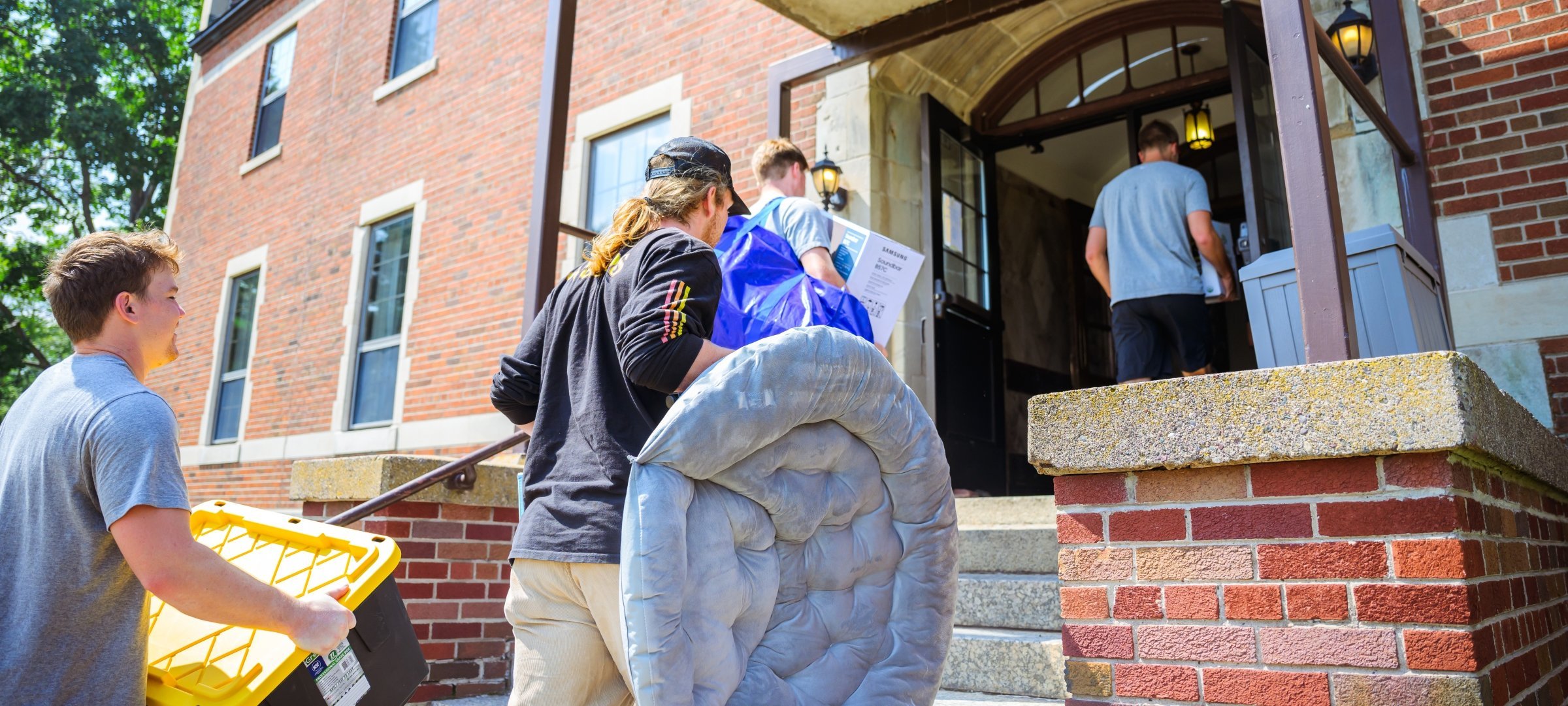 Students carry items into their residence hall