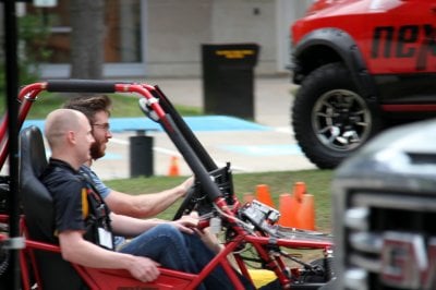 Two researchers in a dune buggy.