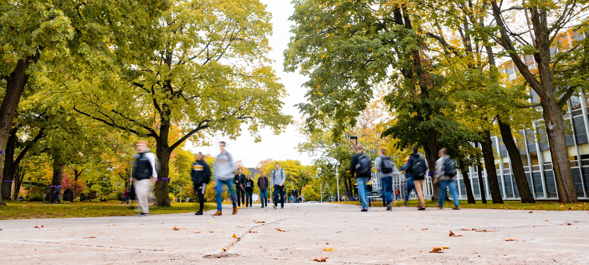 People blurred beyond recognition walking on Michigan Tech's campus.