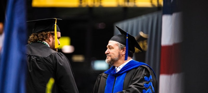 Dean Johnson shaking Anderson Piercey at the 2023 spring commencement