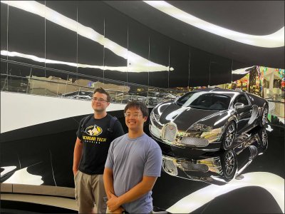 Students standing in fron of a Bugatti Veyron.