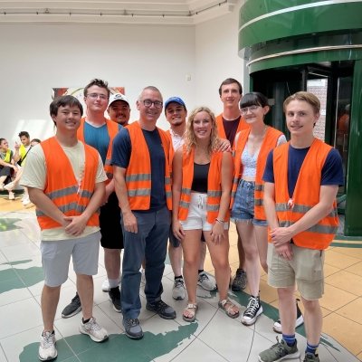 Tech students in orange vests pose as a group.