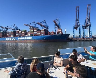 Hamburg port with a Cosco shipping barge at dock.