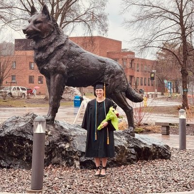 Ivy Stroller in cap and gown next to the Husky Statue.