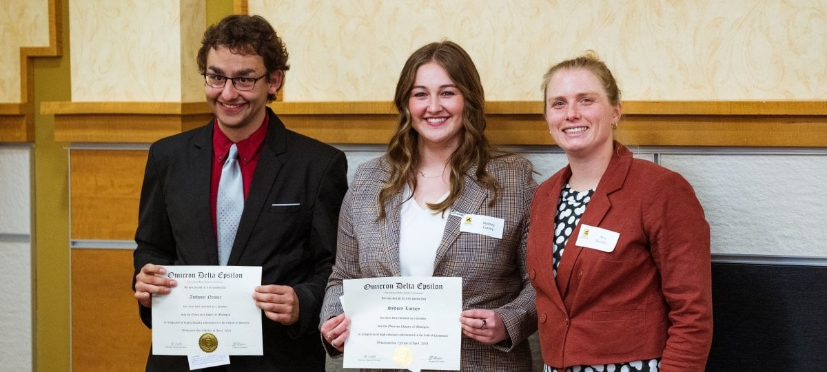 The Omicron Delta Epsilon Inductees holding their induction scrolls