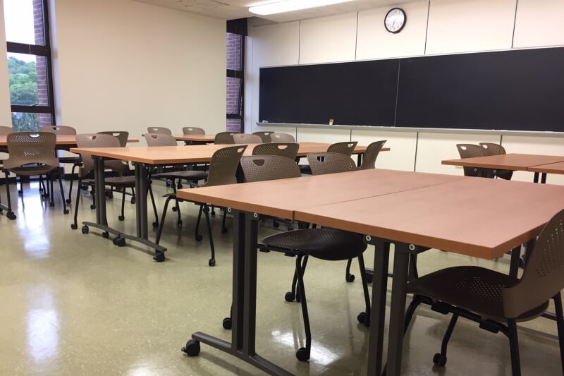 MEEM 405 showing 6 pairs of rectangular tables with 4 chairs each, all with casters, and blackboards along one wall.