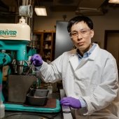 Chemical Engineering Researcher in front of drill with tar substance.