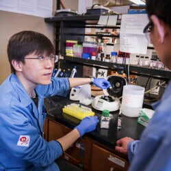 Chemistry student confers with a professor on labwork