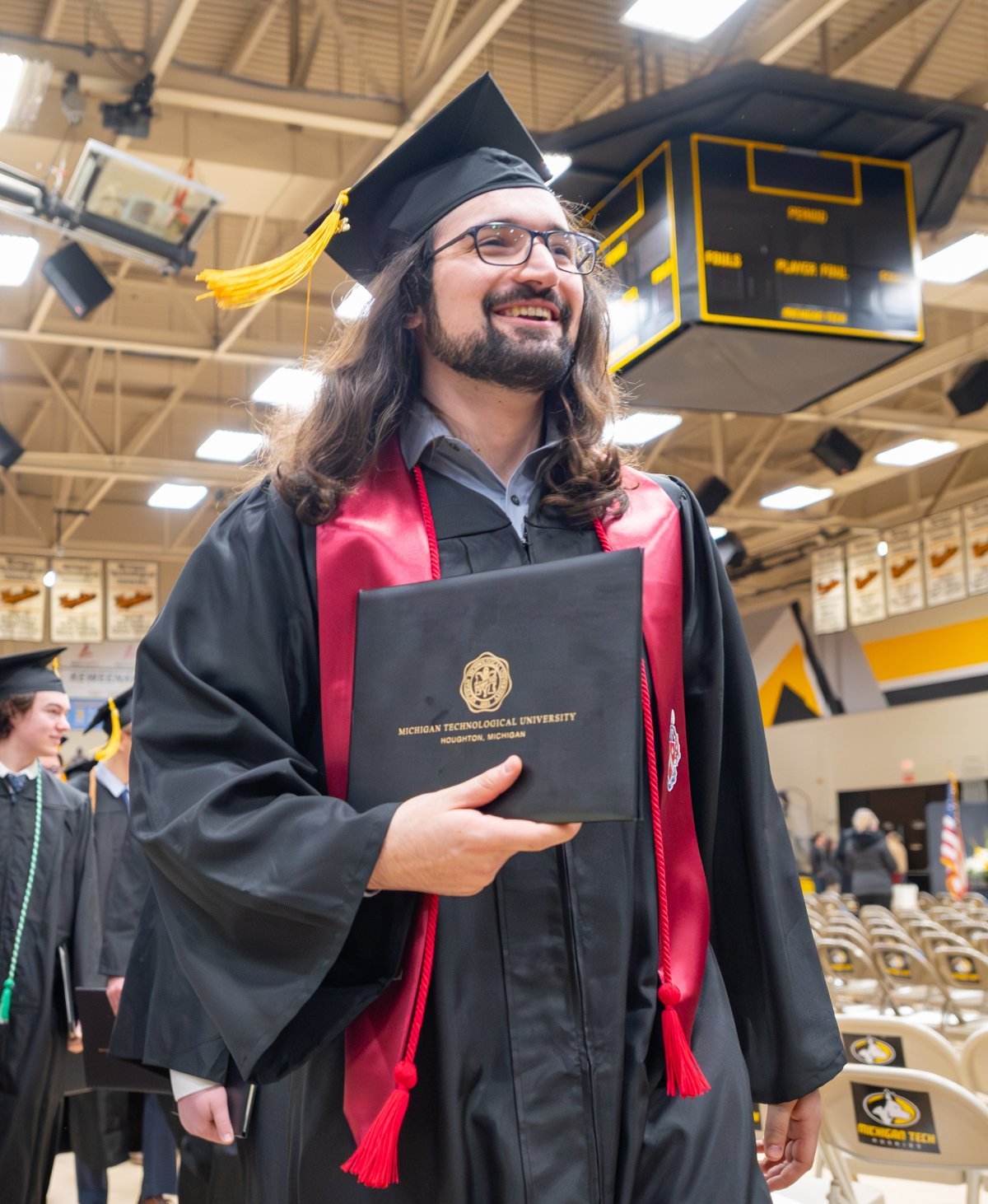 Graduate holding degree at Commencement.