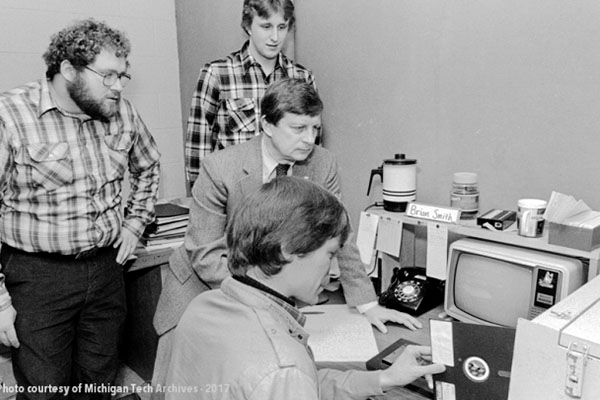 Student loads a large floppy disc into a computer