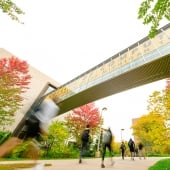 Students walking below the bridge between Rekhi Hall and the Library.