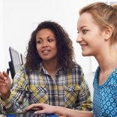 Two women talk and learn computers