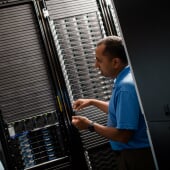 Researcher standing and explaining in server room