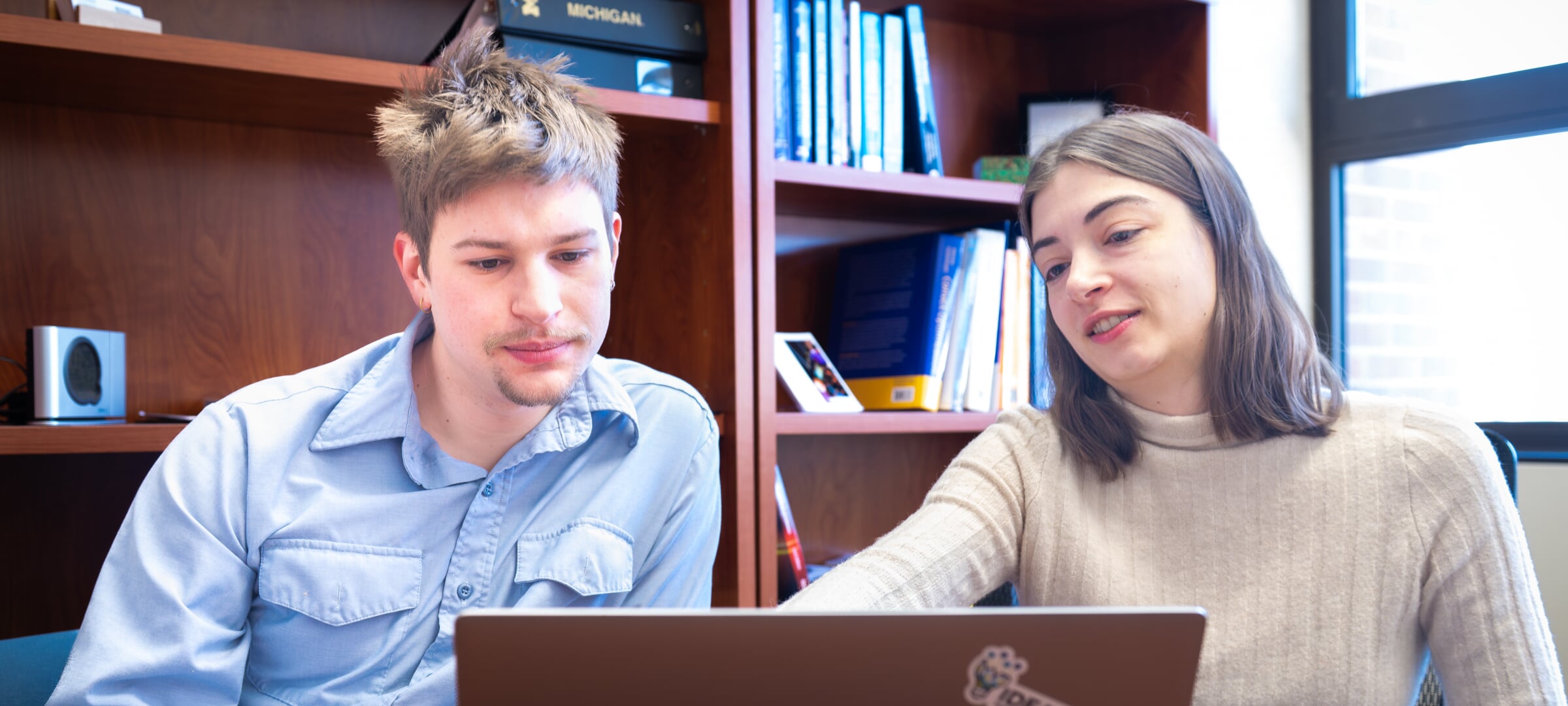 Two students looking at a laptop