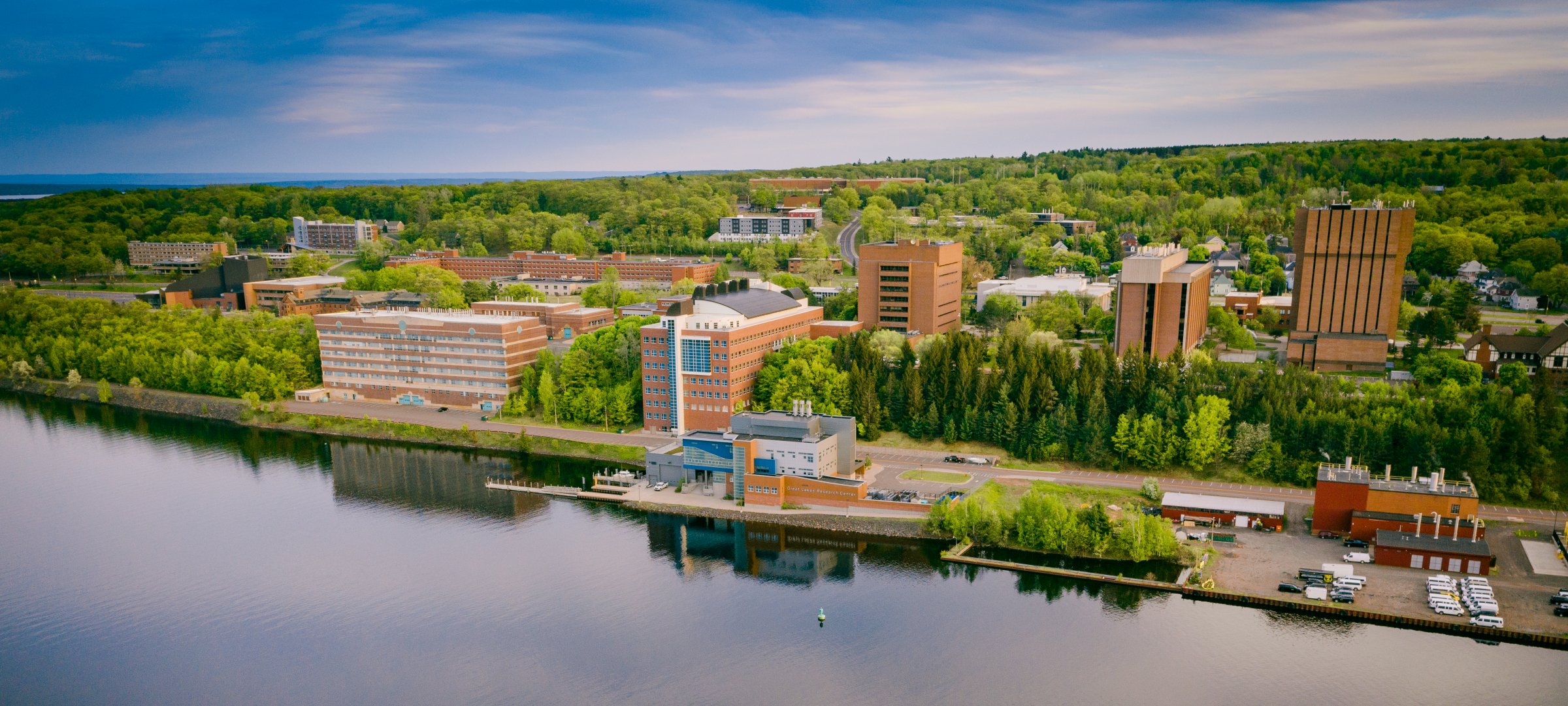 A view of campus across the waterway at sunset. Facility Online Manager (FOM)