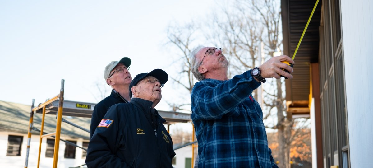 People looking and measuring construction