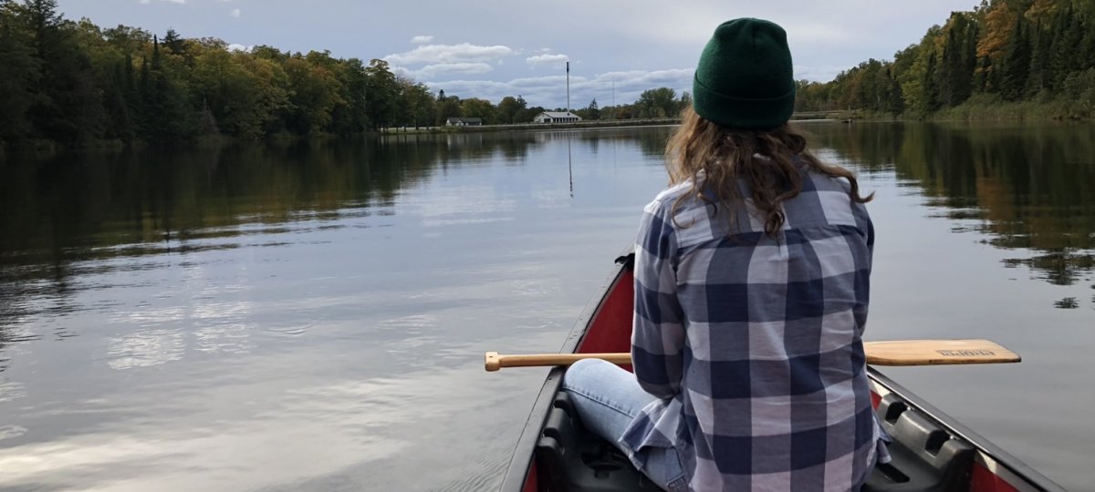 Canoe on the water looking at the Ford Center.