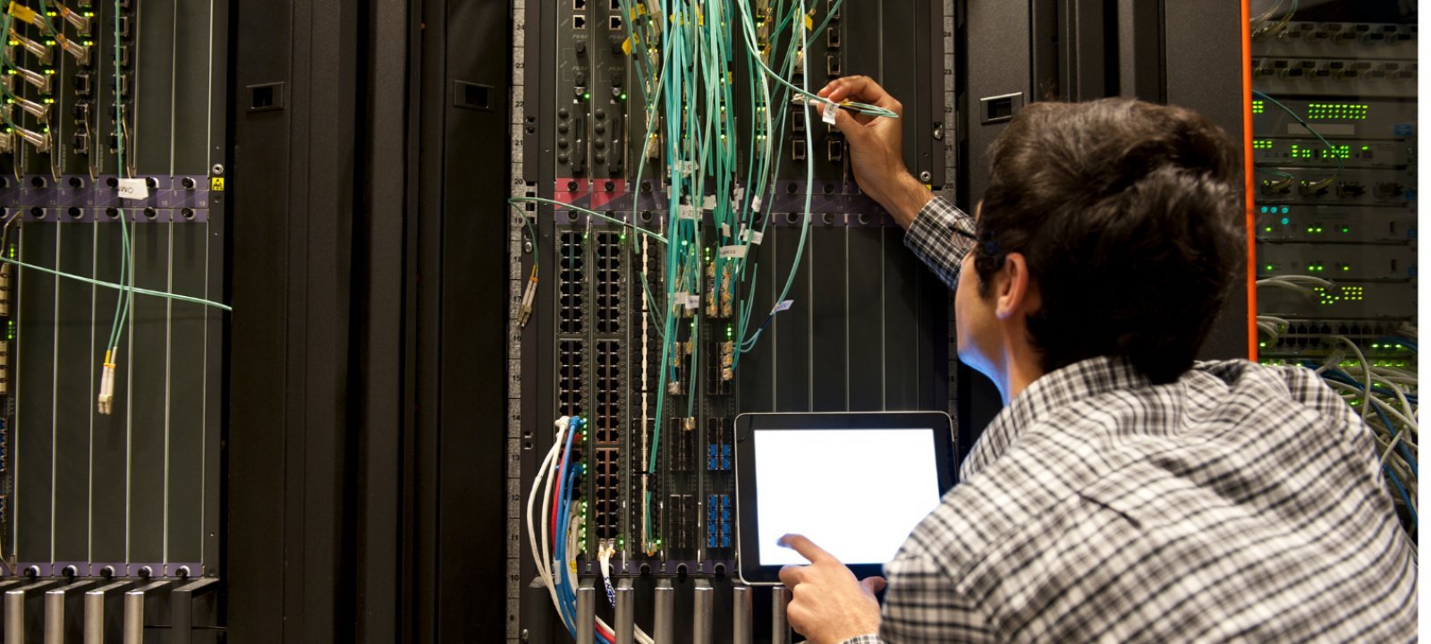 Young engineering working on the wiring of a large computer.