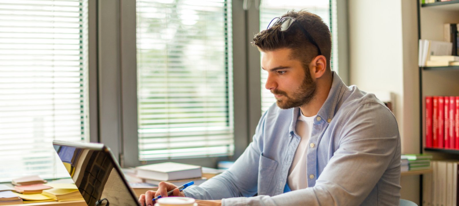 A male online student in front of his computer, working on his global campus program