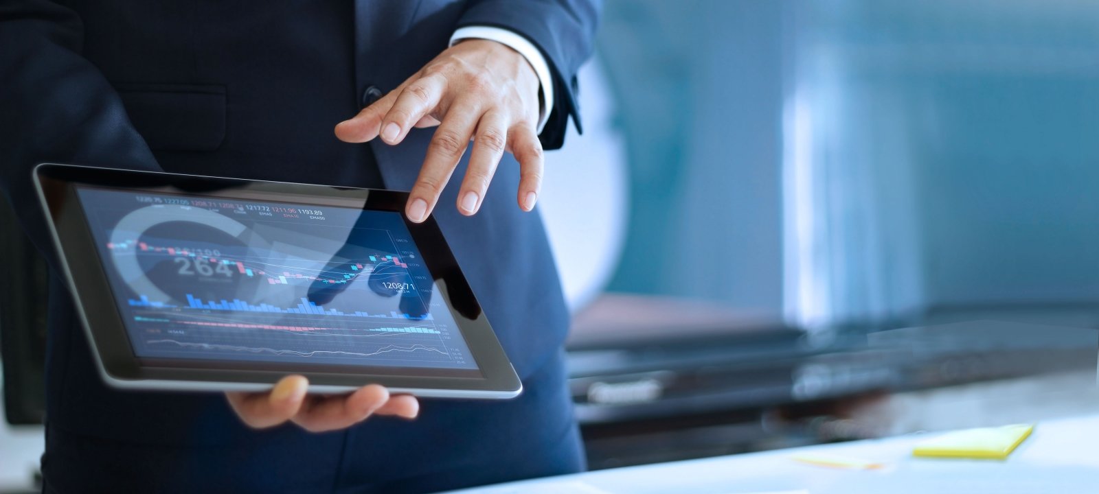 A person holds a tablet in their hand while working on an applied statistics problem.