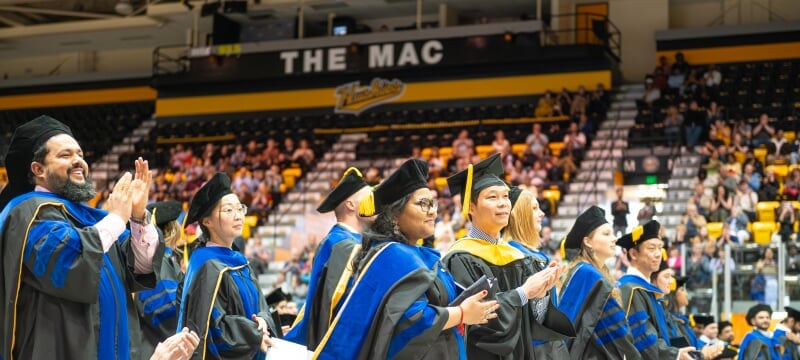 hooded students at commencement ceremony