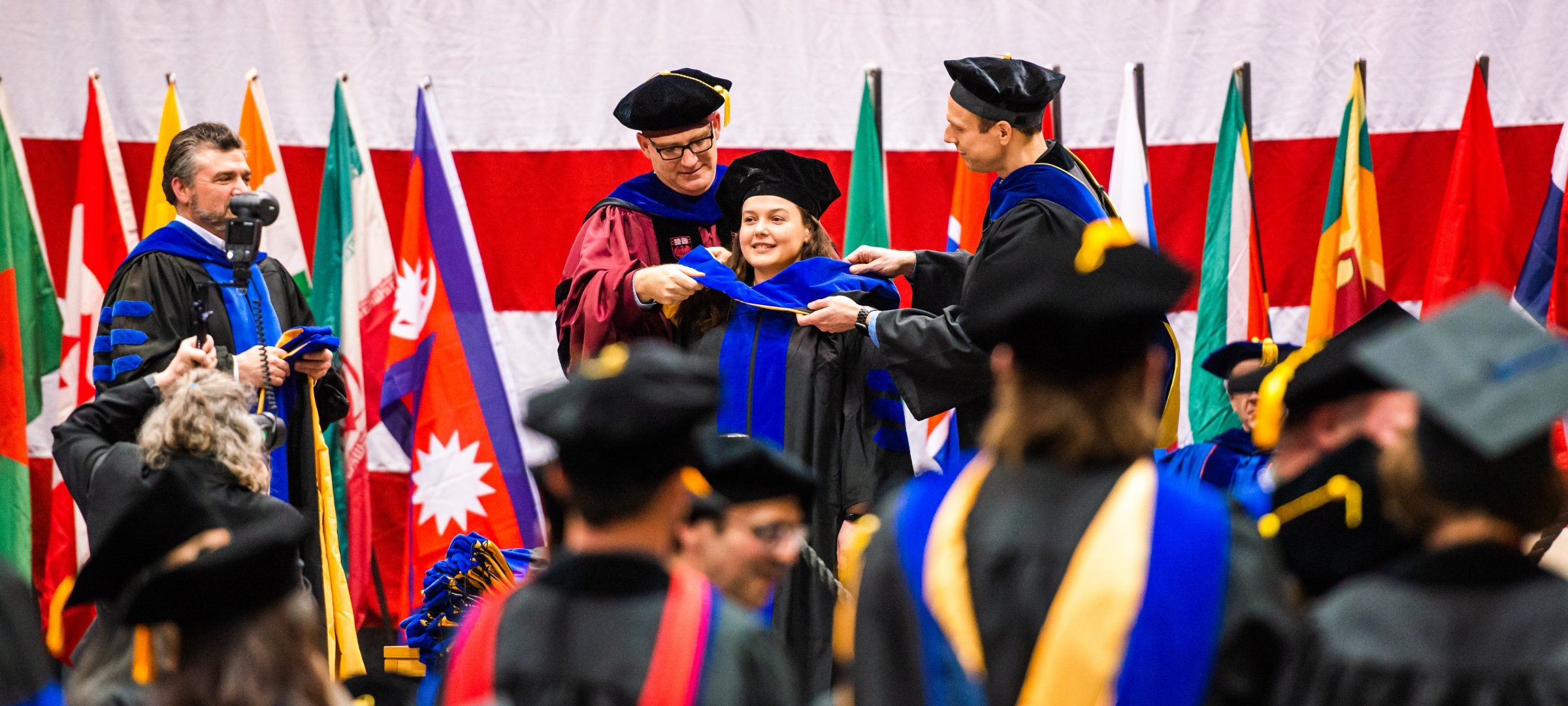 Candidate on stage during hooding at commencement ceremony