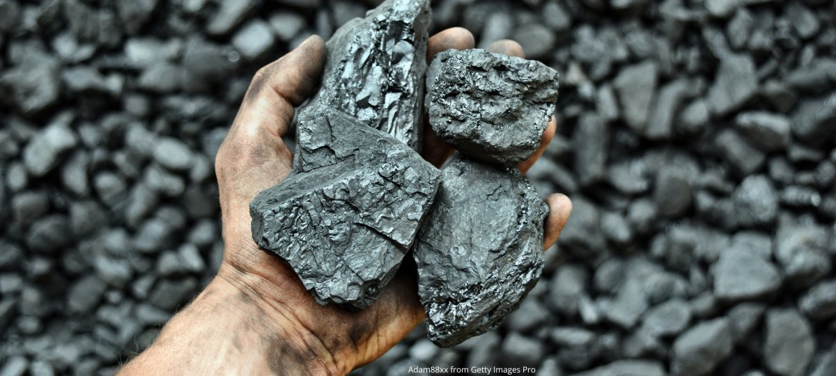 A dirty hand holding rocks containing nickel