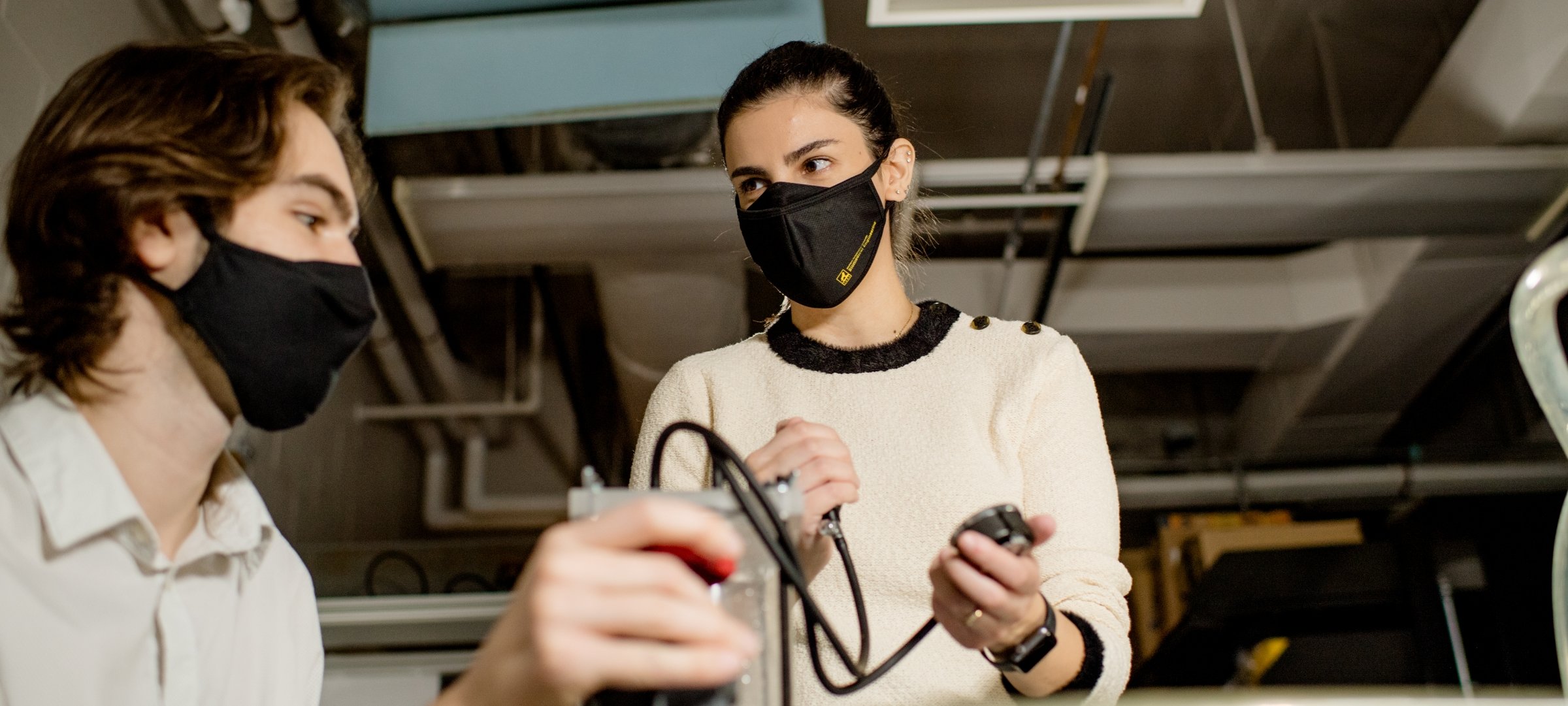 Two students testing fluids in a lab.