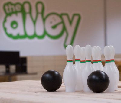 plastice bowling pins with a wall in the distance that says "the alley"