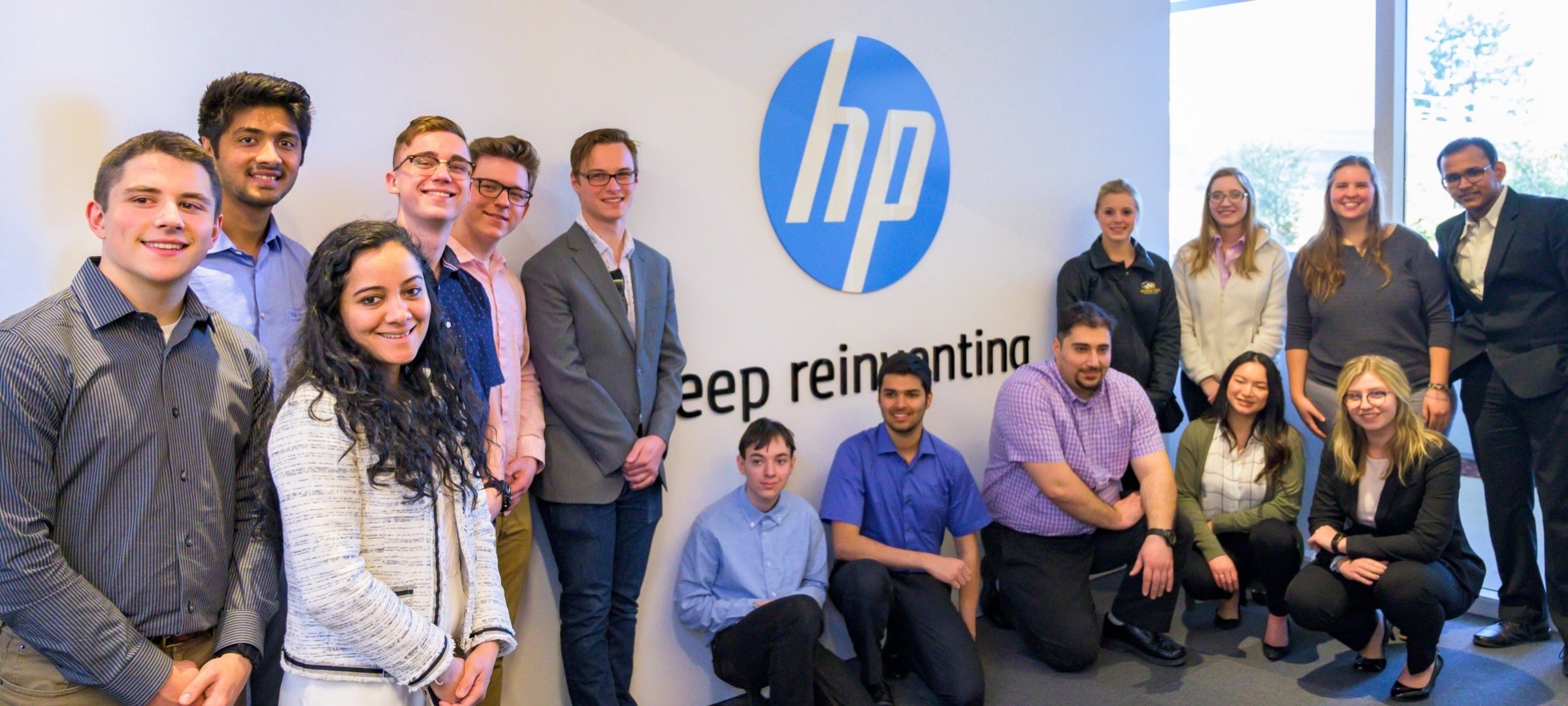 Students who attended the Silicon Valley Trip stand in front of a Hewitt Packer logo.