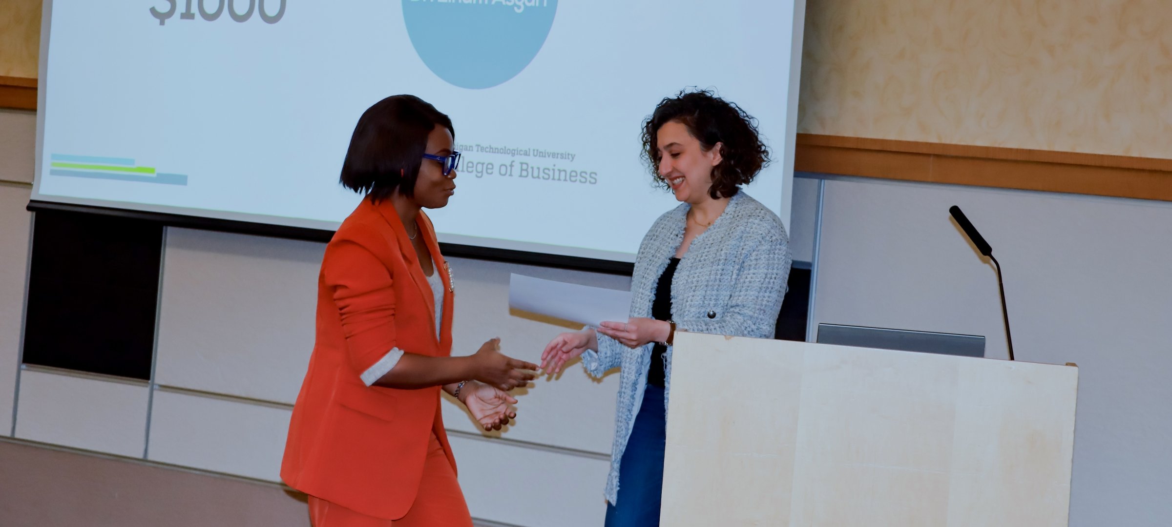 Student receiving an award from a business leader.