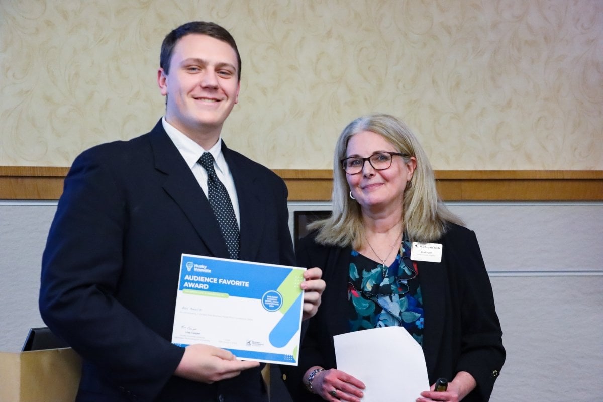 Student who won audience favorite at Elevator Pitch Competion with staff.