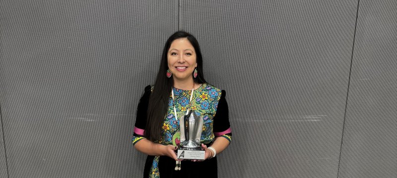 Aurora White holding an award.