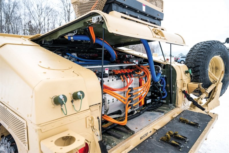 Cover raised on the vehicle to show the motor with several orange and blue hoses.