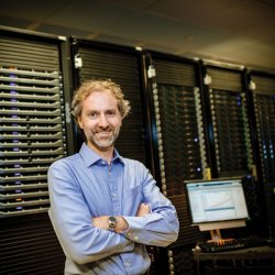 Greg Odegard standing in front of a bank of servers.