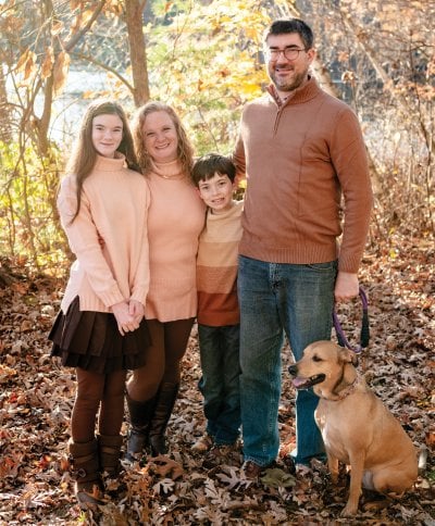 Brandon Dilworth with his wife, two children, and dog outdoors in the fall.