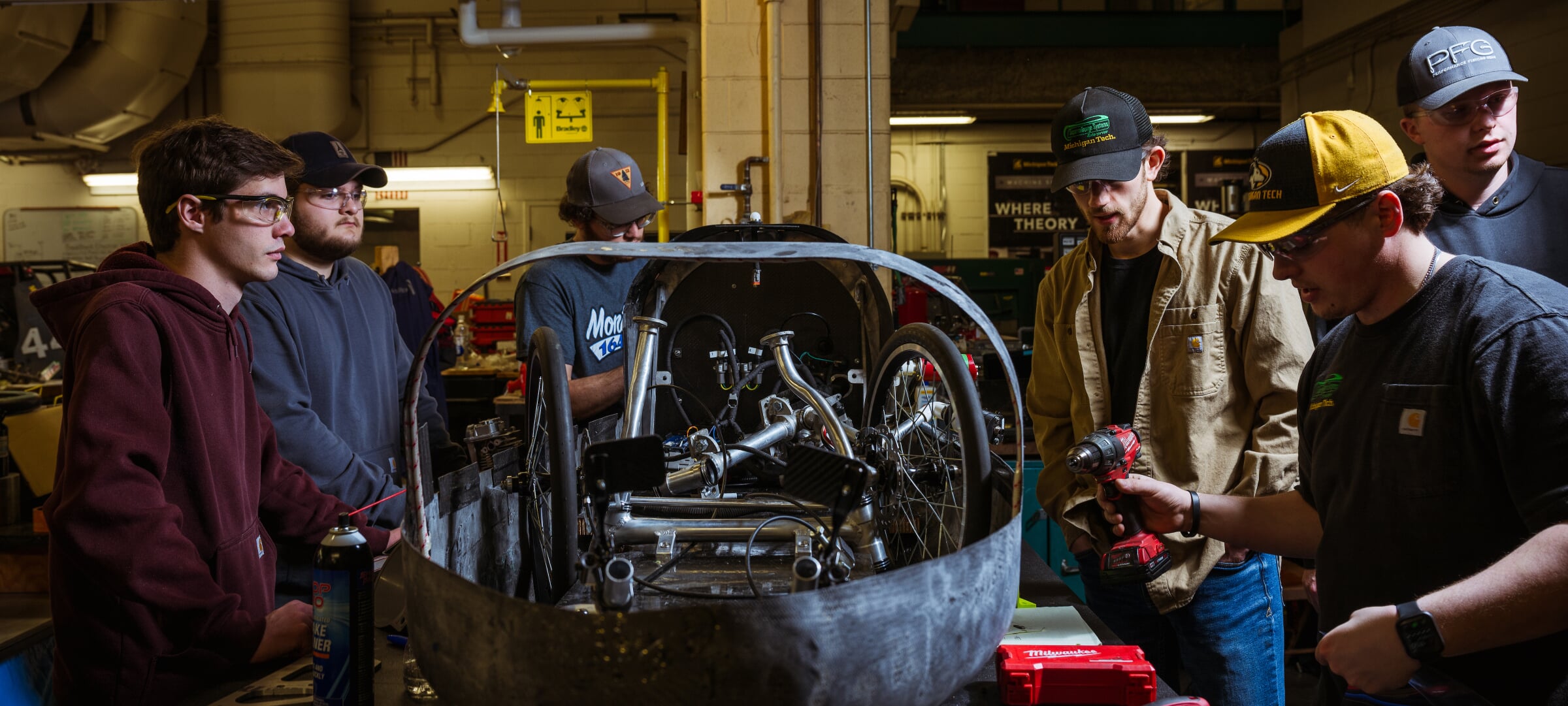 A group of people working on a vehicle they are building