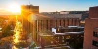 Central campus plaza and buildings with sunset in background.