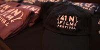 A table with hats and t-shirts featuring the 41N Film Festival logo.