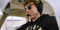 Austin Champine wearing a headset sitting in an airplane.