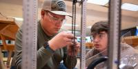 Copper Country Robotics team members put together their robotâ€™s elevator mechanism in the Alley Makerspace.