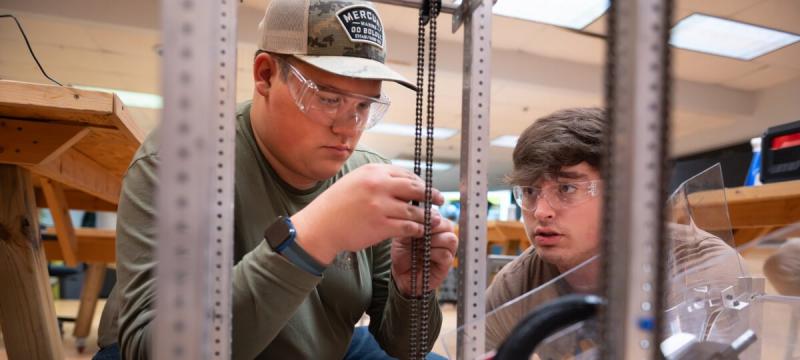 Copper Country Robotics team members put together their robotâ€™s elevator mechanism in the Alley Makerspace.